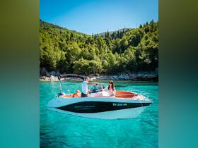 A couple enjoys a sunny day on a BARRACUDA 545 boat, surrounded by stunning turquoise waters and lush greenery — a perfect setting for a romantic getaway.