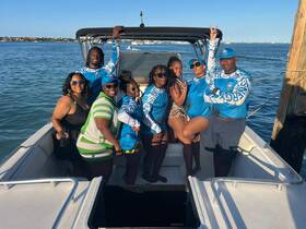 A vibrant group of friends poses on a boat, enjoying their time on the water — perfect for memorable outings and celebrations.