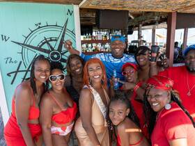 A vibrant group of friends celebrates together at a beach bar, enjoying drinks and fun in the sun — perfect for memorable summer gatherings.