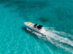 A stunning aerial view of a sleek speedboat cruising through crystal-clear turquoise waters, perfect for adventure seekers and day trips on the water.