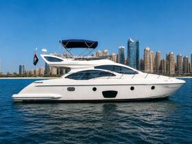 A stunning side view of an Azimut yacht docked in clear waters, with a backdrop of modern skyscrapers, perfect for luxury boating experiences.