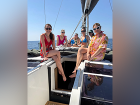 A lively group of friends enjoys a sunny day on a yacht, celebrating together and making unforgettable memories on the water.