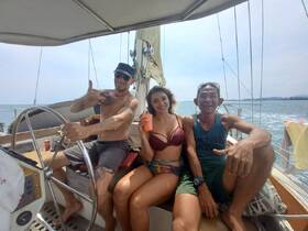 A lively group enjoys a sailing adventure, capturing the joy of the moment with drinks in hand and smiles all around.