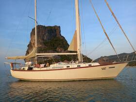 A beautiful sailboat named Geronimo anchored near a stunning rock formation, showcasing the perfect setting for sailing adventures.