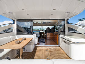 A beautifully designed interior of a luxury yacht featuring a spacious seating area and helm, perfect for relaxing and enjoying the journey on the water.