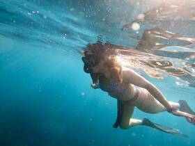 A snorkeler explores the vibrant underwater world, showcasing the beauty of marine life in crystal-clear waters — a perfect adventure for ocean enthusiasts.