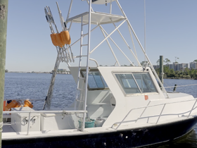 A detailed side view of a fishing boat docked by the water, showcasing its structure and equipment, perfect for fishing enthusiasts.