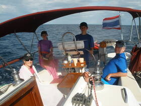 A family enjoys a sailing adventure on the open ocean, capturing the joy of togetherness and exploration aboard their boat.