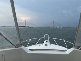 A captivating view from the front of a boat navigating towards a striking bridge, showcasing the beauty of the waterway and the vessel's sleek design.