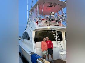 A happy couple poses on the deck of their boat at dusk, showcasing a perfect moment for celebrations or romantic getaways on the water.