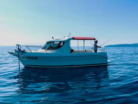 A fisherman casts his line from a small boat, enjoying a serene day on the ocean — perfect for fishing enthusiasts seeking adventure on the water.