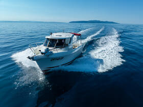 A sleek speedboat glides through calm waters, showcasing its dynamic design and performance on a clear day.