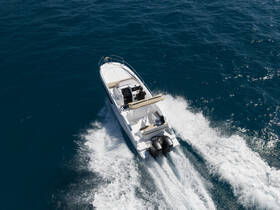 Aerial view of a sleek speedboat cruising through deep blue waters, showcasing its dynamic design and performance on the open sea.