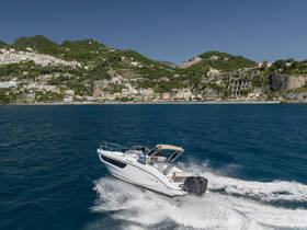 A sleek speedboat navigates the vibrant coastline, showcasing the stunning scenery of lush hills and charming villages — perfect for adventurous outings on the water.