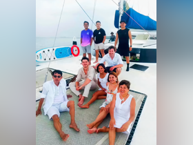 A cheerful group poses together on the deck of a catamaran, enjoying their time on the water — perfect for celebrations and memorable outings.