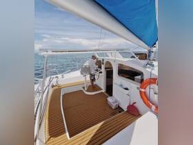 A captain operates the helm of a sleek catamaran, showcasing the spacious interior and modern design, perfect for navigating beautiful waters.