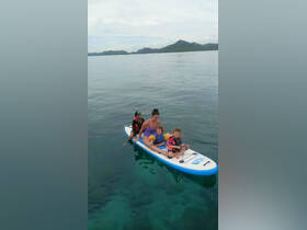A family enjoys paddleboarding together in calm waters, creating lasting memories during their aquatic adventure.