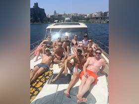 A lively group enjoys sunbathing and drinks on the deck of a boat, creating unforgettable memories under the sun.