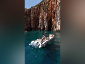 A lively group enjoys a day on the water aboard a boat, surrounded by stunning cliffs and crystal-clear waters — perfect for adventure and exploration.