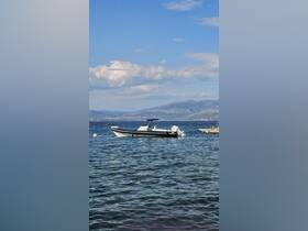 A sleek speedboat anchored in clear waters, surrounded by stunning coastal scenery — perfect for a day of exploration on the water.