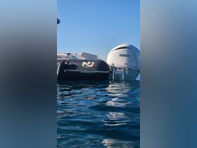 A close-up view of a Yamaha outboard motor alongside a black inflatable boat, showcasing the sleek design and functionality of modern boating equipment.