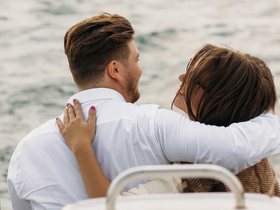 A couple embraces on a boat, enjoying a romantic moment together on the water — perfect for celebrating love and special occasions.