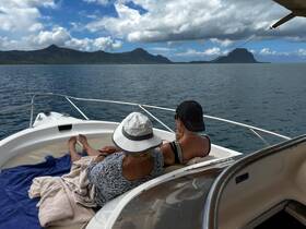 A couple relaxes on the bow of a boat, enjoying stunning ocean views and the serene atmosphere — perfect for a peaceful getaway.