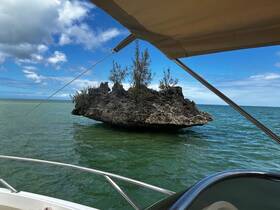 A picturesque view of a rocky island surrounded by tranquil waters, captured from the deck of a boat — perfect for showcasing the beauty of nature while on a boating adventure.