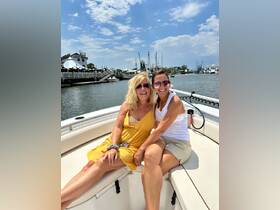 Two friends enjoy a sunny day on a boat, capturing joyful moments together — perfect for memorable outings and adventures on the water.