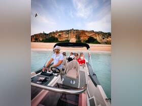 A lively group enjoys a boat ride near a scenic beach, perfect for creating unforgettable memories on the water.