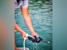A person cleans snorkeling gear at the water's edge, showcasing essential amenities for a fun day on the water.