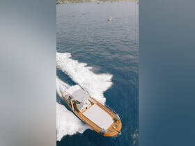 An aerial view of a sleek speedboat cruising through deep blue waters, showcasing its elegant design and perfect for thrilling adventures on the sea.