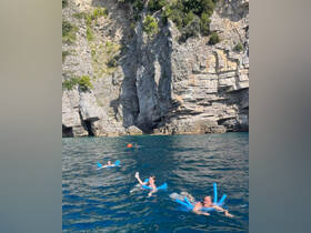 A group enjoys a fun swimming experience near stunning cliffs, showcasing the perfect blend of adventure and relaxation in the water.