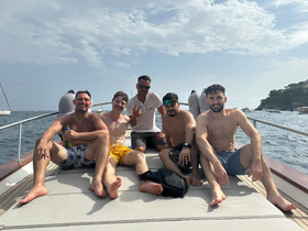 A group of friends enjoys a sunny day on a boat, capturing the essence of friendship and celebration on the water.