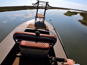 A view from the helm of a boat showcasing the comfortable seating and control area, perfect for navigating through serene waters.