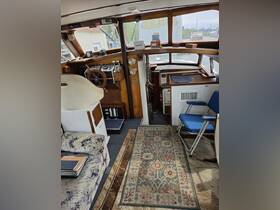 A cozy interior view of a boat's helm and seating area, showcasing the functional layout and inviting atmosphere for a comfortable boating experience.