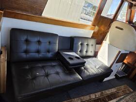 Interior view of a cozy seating area on a boat, featuring plush black cushions and a convenient cup holder, perfect for relaxing while cruising.