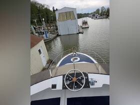 View of the helm and console from the front of a boat, showcasing the steering wheel and control panel, ideal for navigation and boating enthusiasts.