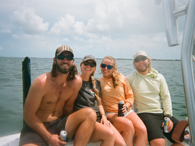 A group of friends enjoys a fun day on the water, relaxing on a boat with drinks in hand — perfect for creating unforgettable memories on a boating adventure.