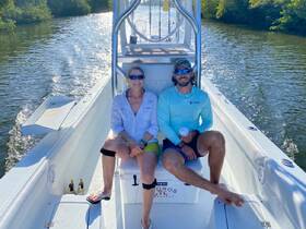 A couple enjoys a relaxing moment on a boat, surrounded by serene waterways — perfect for a day of exploration and leisure.