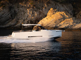 A sleek speedboat glides through the water, showcasing its modern design against a stunning rocky backdrop — perfect for thrilling adventures on the open sea.