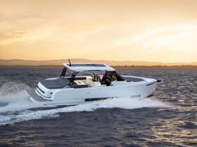 A sleek speedboat cuts through the waves at sunset, showcasing its modern design and performance on the water.