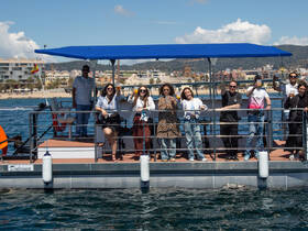 A lively group celebrates aboard a pontoon boat, raising drinks against a scenic backdrop — perfect for unforgettable gatherings on the water.