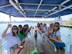 A lively group of friends enjoys drinks and laughter aboard a boat, perfect for celebrations and memorable outings on the water.