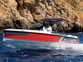 A couple enjoys a thrilling ride on a sleek boat, showcasing the excitement of on-water adventures against a stunning rocky backdrop.
