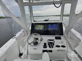 A detailed view of the helm and console area inside a boat, showcasing modern navigation equipment and a clean, spacious layout.