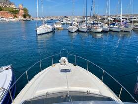 A stunning view from the front of a yacht docked in a marina, surrounded by other boats and clear blue waters, perfect for showcasing luxury boating experiences.