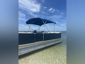 A sleek pontoon boat anchored in shallow waters, showcasing its spacious design and comfortable seating, perfect for leisurely outings on the water.