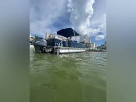 A side view of a pontoon boat docked near the shore, showcasing its spacious design and inviting atmosphere for a day on the water.