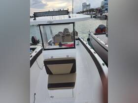 Interior view of a boat's helm and seating area, showcasing comfortable seating and a well-equipped console, ideal for a day on the water.